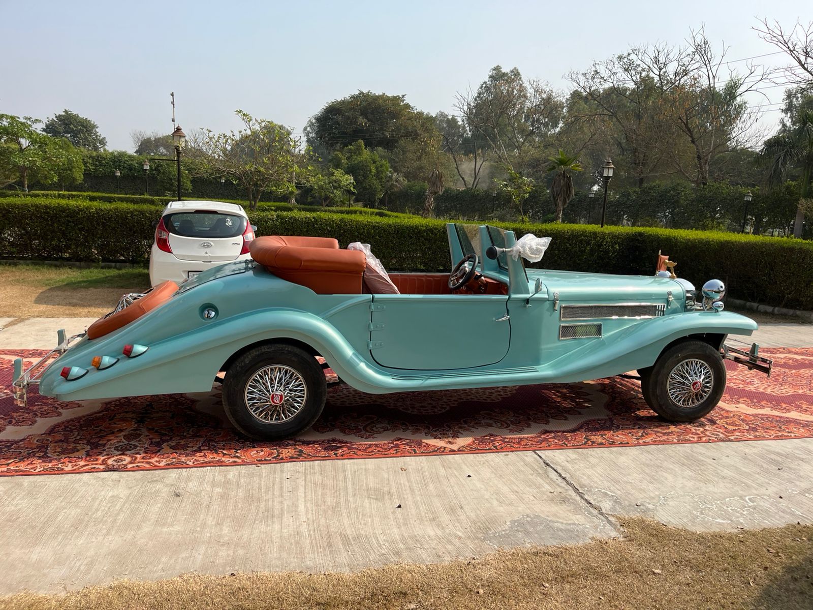Sky-blue vintage convertible on a carpet, side view