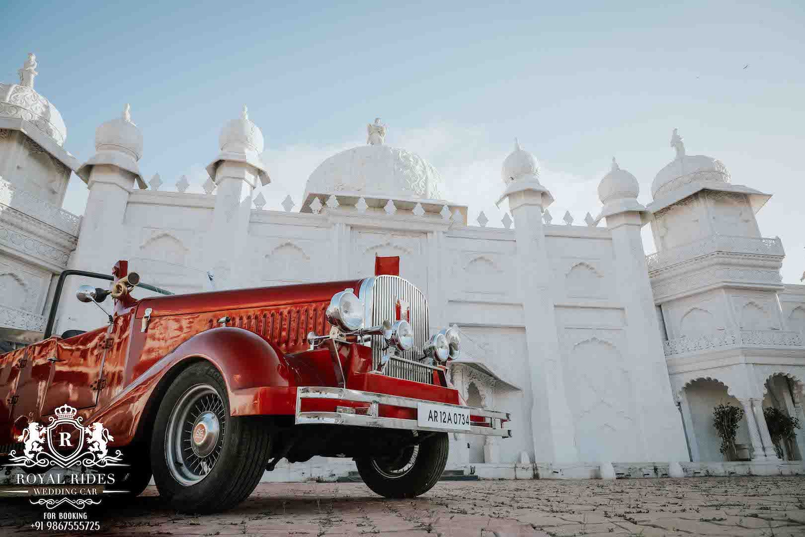 Red vintage car in front of a white palace-style venue